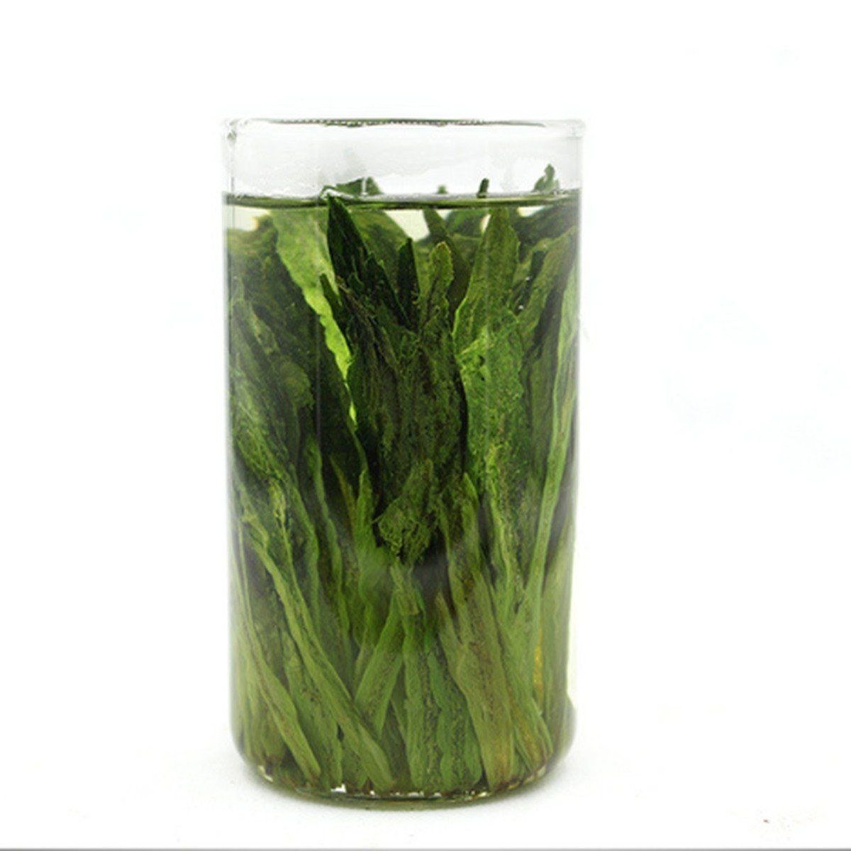 Taiping Houkui leaves standing upright while they steep in a tall glass